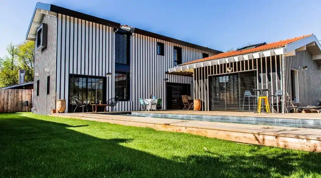 Maison contemporaine avec une piscine et des façades en bois, réalisée par un architecte spécialisé dans les projets résidentiels. ​​